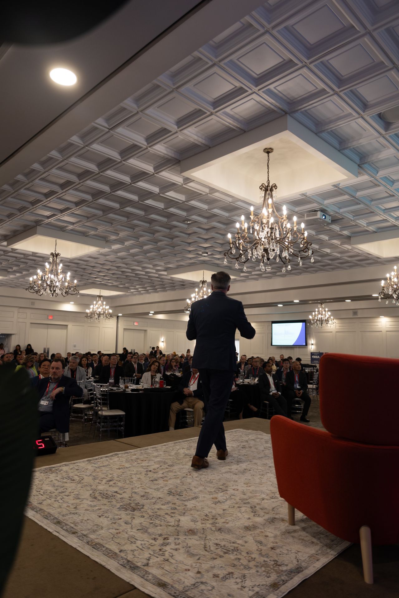 Peter Hall delivering a keynote on stage.
